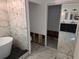 Luxurious bathroom featuring an elegant soaking tub, stylish black and white tile, and modern vanity at 301 W Chelsea St, Tampa, FL 33603