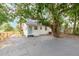 White cottage with stone patio and a large tree in the front yard at 3170 6Th S Ave, St Petersburg, FL 33712