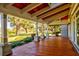 Spacious front porch with wooden flooring and a view of the park at 518 Riverside Dr, Tarpon Springs, FL 34689