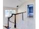 Upper hallway with whitewashed floors and staircase at 518 Riverside Dr, Tarpon Springs, FL 34689