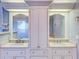 A bathroom features dual sinks, a central vanity, and chrome fixtures, blending functionality with style at 518 Riverside Dr, Tarpon Springs, FL 34689