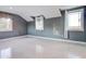 A spacious bedroom featuring gray walls and light floors is lit by three windows at 518 Riverside Dr, Tarpon Springs, FL 34689