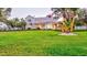 Sprawling front lawn leads to a well-maintained two-story home with a welcoming covered porch at 518 Riverside Dr, Tarpon Springs, FL 34689