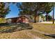 Exterior view of the single-story house featuring a spacious yard with a covered parking and front porch at 7176 Westwind St, Weeki Wachee, FL 34607