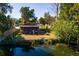 Exterior view of a cozy home featuring a screened-in porch and waterfront access at 7176 Westwind St, Weeki Wachee, FL 34607