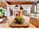 Farmhouse dining table in a kitchen with wood beams and hardwood floors at 13801 Lake Village Pl, Tampa, FL 33618