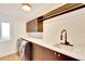 Modern laundry room with dark cabinets and quartz countertop at 13801 Lake Village Pl, Tampa, FL 33618