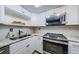 Updated kitchen with stainless steel appliances and white cabinets at 2739 Sherbrooke Ln # B, Palm Harbor, FL 34684
