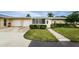 Tan house with attached garage, landscaped yard, and walkway at 2739 Sherbrooke Ln # B, Palm Harbor, FL 34684