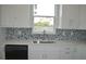 Modern kitchen sink with white cabinets and blue backsplash at 3915 W Robson St, Tampa, FL 33614