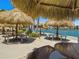 Outdoor patio with tables and tiki umbrellas overlooking waterfront at 7600 Sun Island S Dr # 107, South Pasadena, FL 33707