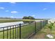 Backyard with a pond view, privacy fence, and lush grass at 8968 Parsons Hill Blvd, Wesley Chapel, FL 33545