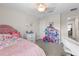 Bedroom with a pink bed, dollhouse, and white chair at 8968 Parsons Hill Blvd, Wesley Chapel, FL 33545