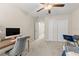 Bright bedroom with carpeted floor, desk, and double doors at 8968 Parsons Hill Blvd, Wesley Chapel, FL 33545