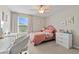 Bedroom with pink bed, vanity, and window at 8968 Parsons Hill Blvd, Wesley Chapel, FL 33545