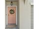 Light pink front door with a gold and white holiday wreath at 8968 Parsons Hill Blvd, Wesley Chapel, FL 33545