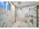 Large walk-in shower with marble tile and pebble floor at 17444 2Nd E St, Redington Shores, FL 33708