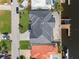 Aerial view of a modern home with a dark roof, lush green lawn, and waterfront access at 1954 Iowa Ne Ave, St Petersburg, FL 33703