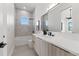 Modern bathroom featuring dual sink vanity, tub, window, and light gray tiled shower surround at 1954 Iowa Ne Ave, St Petersburg, FL 33703