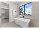 Bright bathroom with a standalone tub, large window, and an adjacent walk-in closet at 1954 Iowa Ne Ave, St Petersburg, FL 33703