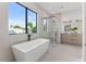 Luxurious bathroom featuring a soaking tub, glass shower, and dual vanity sinks at 1954 Iowa Ne Ave, St Petersburg, FL 33703