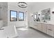 Bathroom with dual sinks, modern fixtures, chandelier lighting and free standing soaking tub at 1954 Iowa Ne Ave, St Petersburg, FL 33703