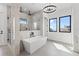 Bathroom with dual sinks, modern fixtures, chandelier lighting, free standing soaking tub and glass shower at 1954 Iowa Ne Ave, St Petersburg, FL 33703