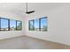 Bright bedroom with hardwood floors, contemporary ceiling fan, and large windows with treeline views at 1954 Iowa Ne Ave, St Petersburg, FL 33703