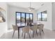 Modern dining room boasts contemporary chandelier, art, and view through black frame windows to the waterway at 1954 Iowa Ne Ave, St Petersburg, FL 33703