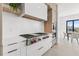 A modern kitchen with a Wolf range, marble backsplash and adjacent dining area at 1954 Iowa Ne Ave, St Petersburg, FL 33703