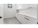 Minimalist laundry room with white cabinets, black hardware, modern faucet, and gray floors at 1954 Iowa Ne Ave, St Petersburg, FL 33703