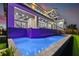 Backyard pool at night with the home's exterior lights reflecting in the water at 1954 Iowa Ne Ave, St Petersburg, FL 33703
