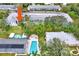 Aerial view of the property with a community pool, pool house, and lots of greenery at 200 Glennes Ln # 111, Dunedin, FL 34698
