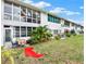 Cozy backyard space with small patio seating, a table, and mature landscaping at 200 Glennes Ln # 111, Dunedin, FL 34698