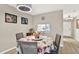 Charming dining area with round table, floral tablecloth, and pass-through view to the adjacent well-lit kitchen at 200 Glennes Ln # 111, Dunedin, FL 34698