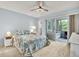 Cozy bedroom with a ceiling fan, floral bedding, and sliding glass doors to a sunroom, creating a relaxing retreat at 200 Glennes Ln # 111, Dunedin, FL 34698