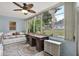 Bright sunroom with large windows, ceiling fan, daybed, and an antique desk at 200 Glennes Ln # 111, Dunedin, FL 34698