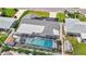 An aerial view of a home featuring solar panels and a screened pool area, showcasing a well-maintained property and yard at 2132 Academy Dr, Clearwater, FL 33764