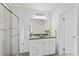 Bright bathroom featuring a vanity with green countertops, fresh towels, and a glass enclosed shower at 2132 Academy Dr, Clearwater, FL 33764