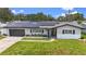 Charming home with a well-manicured lawn, solar panels, and updated exterior, offering a blend of style and sustainability at 2132 Academy Dr, Clearwater, FL 33764