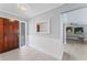 Inviting foyer with wood-look tile, a decorative mirror, and access to the living room at 2132 Academy Dr, Clearwater, FL 33764