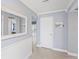 Bright hallway featuring wood-look tile flooring, a large mirror, and white trim at 2132 Academy Dr, Clearwater, FL 33764