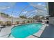 A screened pool with an expansive patio, tropical landscaping, and plenty of seating for outdoor relaxation and entertainment at 2132 Academy Dr, Clearwater, FL 33764