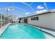 A screened pool with an expansive patio, black trimmed french doors, and perfect for outdoor relaxation and entertainment at 2132 Academy Dr, Clearwater, FL 33764