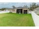 House back view, showcasing a large yard and screened patio at 2622 Bonterra Blvd, Valrico, FL 33594