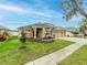 Two-story house with tan exterior, three-car garage, and landscaped yard at 2622 Bonterra Blvd, Valrico, FL 33594