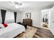 Well-lit bedroom with wood-look flooring and access to a bathroom at 2920 Star Apple Ct, Palm Harbor, FL 34684