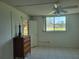 Bedroom with dresser, ceiling fan, and window with view of trees and building at 4915 Bay Ne St # 122, St Petersburg, FL 33703