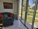 Living room with leather couch, ottoman, and sliding glass doors to patio with yard view at 4915 Bay Ne St # 122, St Petersburg, FL 33703