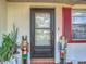 Charming front door flanked by nutcrackers and lush plants at 5930 Della Dr, Holiday, FL 34690